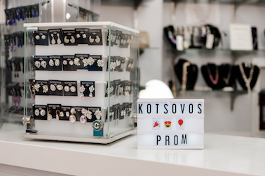 Kotsovos prom dress earrings and sign reading 'kotsovos prom'